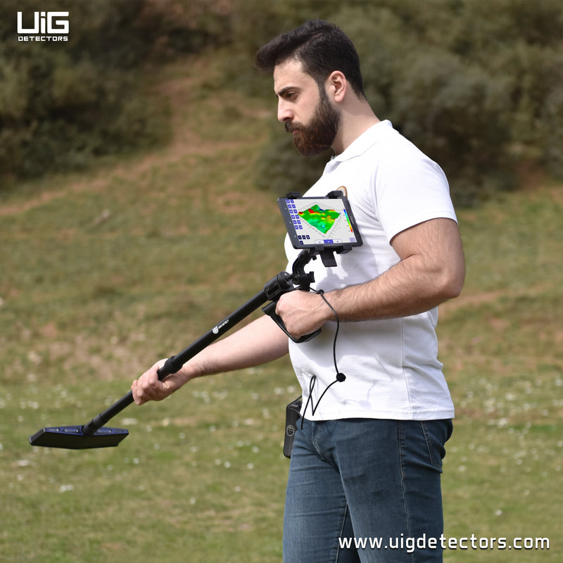 UIG ground scanner device for detecting precious metals and underground cavities, shown in a natural outdoor setting.